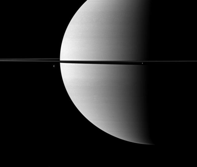 Resembling ornaments hanging from Saturn rings, two moons accent this portrait of the planet captured by NASA Cassini spacecraft. The moon Enceladus is on the right. Dione is on the left.