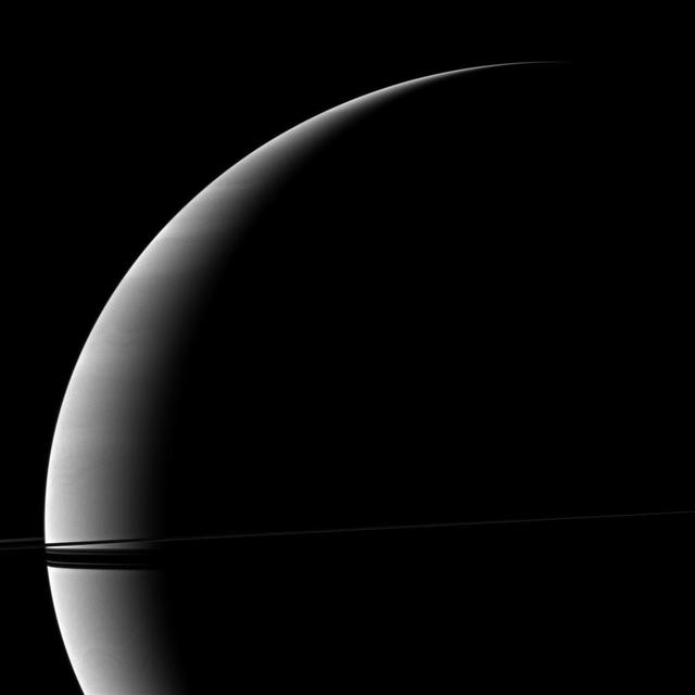 Resembling a thin ribbon wrapped around the crescent of the planet, Saturn rings are seen edge-on by NASA Cassini spacecraft.