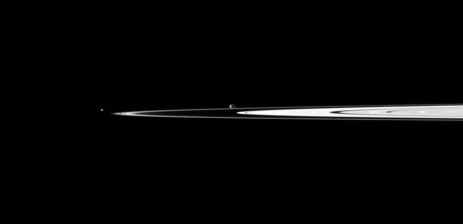 A pair of Saturn small moons orbit near the planet rings, which appear well illuminated in this view captured by NASA Cassini spacecraft. Janus is near the center of the image and Pandora is on the left.