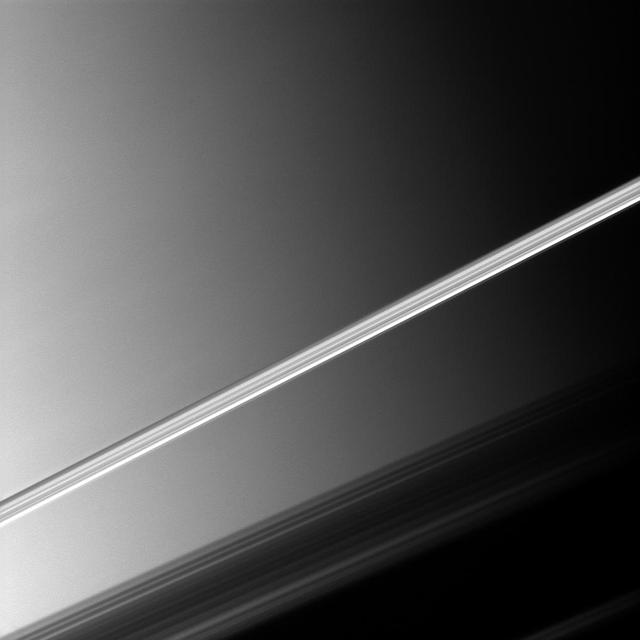 Saturn brightly lit rings slice across this NASA Cassini spacecraft picture taken before a backdrop of the planet clouds.