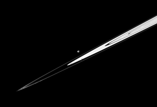 A pair of Saturn small satellites, Janus and Pandora, accompany the planet rings in this image from NASA Cassini spacecraft presenting the view in dramatic diagonal fashion.