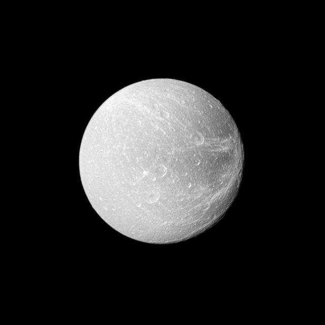Wispy terrain stretches across the trailing hemisphere of Saturn moon Dione on the right of this image taken by NASA Cassini spacecraft during the spacecraft flyby on April 7, 2010.
