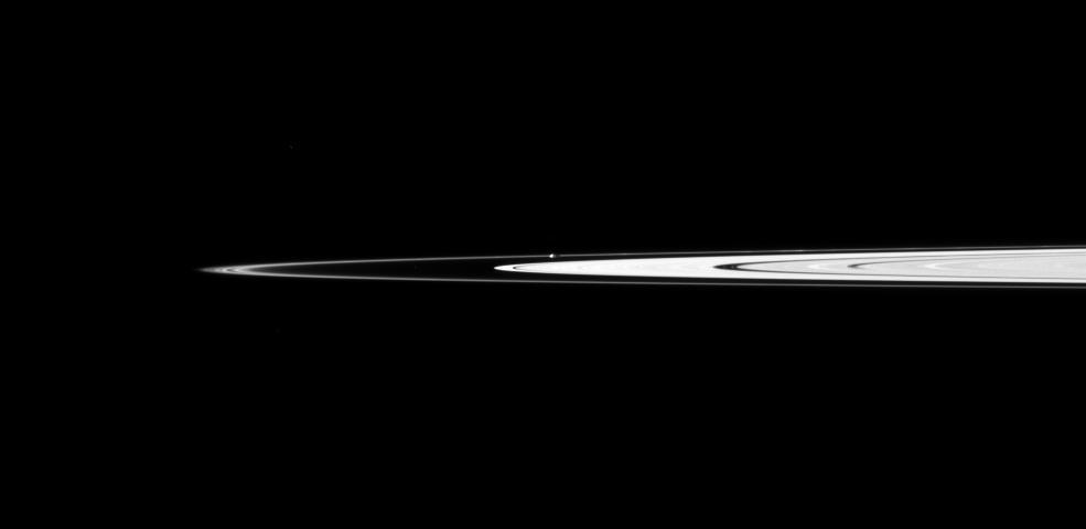 Saturn small, potato-shaped moon Prometheus orbits between the main rings and the thin F ring in this view captured by NASA Cassini spacecraft.