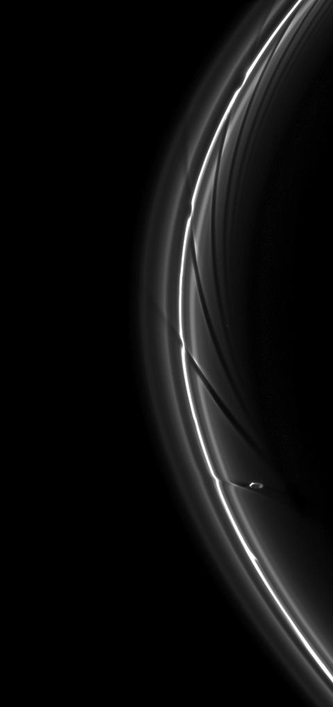 The gravity of potato-shaped Prometheus periodically creates streamer-channels in the F ring, and the moon handiwork can be seen in the dark channels in this image from NASA Cassini spacecraft.