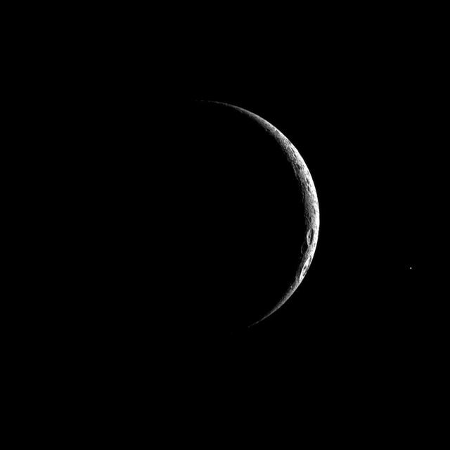 A thin crescent of cratered terrain is illuminated on Saturn third largest moon, Dione in this image captured by NASA Cassini spacecraft.