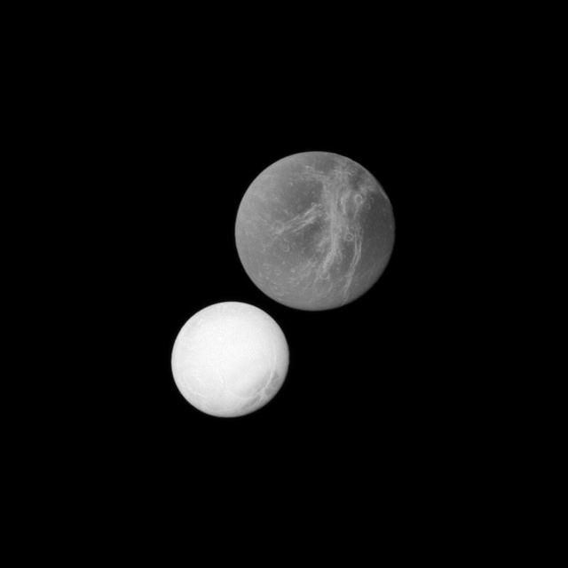 At top of this image, Saturn moon Dione may appear closer to the spacecraft because it is larger than the moon Enceladus in the lower left. However, Enceladus was actually closer to the spacecraft in this image captured by NASA Cassini spacecraft.