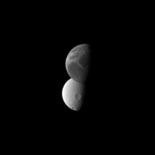 Saturn wispy moon Dione lies in front of the cratered surface of the moon Tethys, as seen by NASA Cassini spacecraft. Dione is closest to the spacecraft here.