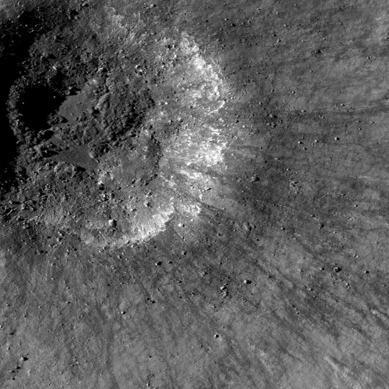 This is a view from NASA Lunar Reconnaissance Orbiter of a very young impact crater in Balmer basin. The dark streamers are impact melt splashes thrown out during the crater formation.