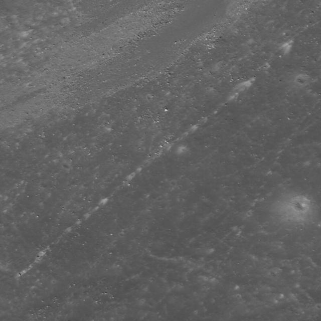 High-albedo marks on the lunar surface left by a boulder bouncing down the northeast wall of farside highlands crater Moore F in this image captured by NASA Lunar Reconnaissance Orbiter.