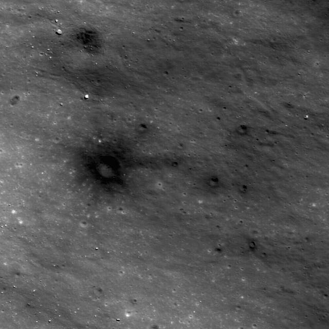 This image from NASA Lunar Reconnaissance Orbiter shows dark materials excavated by later small impacts show up clearly on the bright ejecta of a small lunar crater to the west.