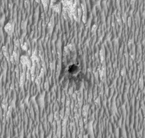 This image, acquired by NASA Mars Reconnaissance Orbiter, shows the rover Opportunity perched on the edge of Concepci?n crater, a fresh crater with dark rays that clearly overprint the north-trending, wind-shaped ripples, in Meridiani Planum.