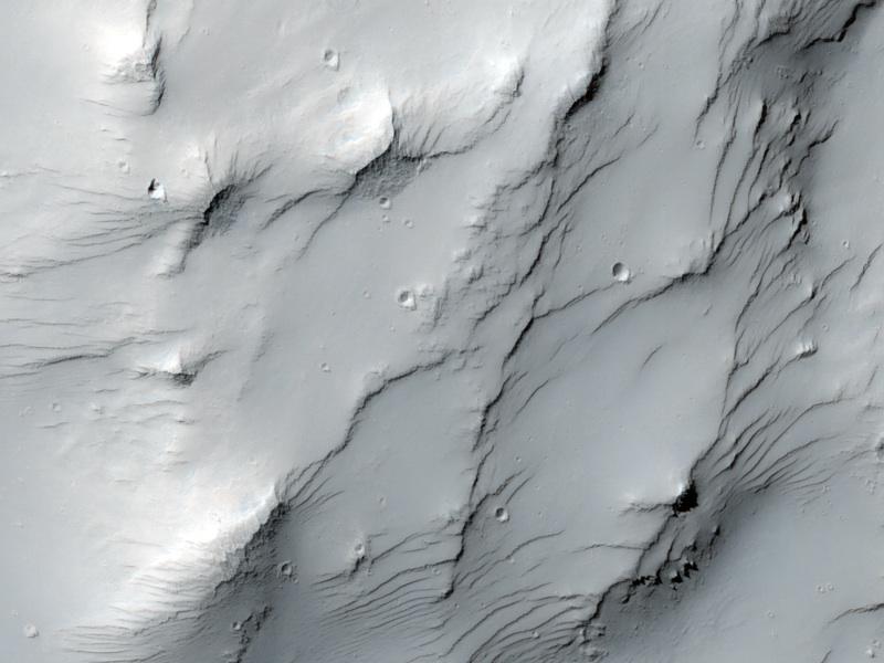 This image captured by NASA Mars Reconnaissance Orbiter covers some high-standing topography just outside the rim of an impact crater about 30 kilometers 19 miles in diameter near a Martian hill named Zephyria Tholus.