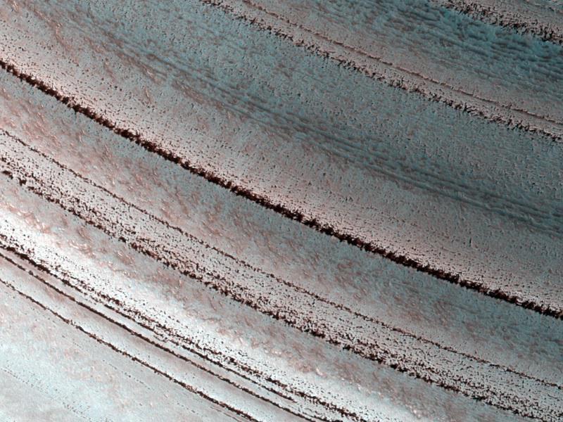 The Martian north polar layered deposits are an ice sheet much like the Greenland ice sheet on the Earth in this image from NASA Mars Reconnaissance Orbiter. This Martian ice sheet contains many layers that record variations in the Martian climate.