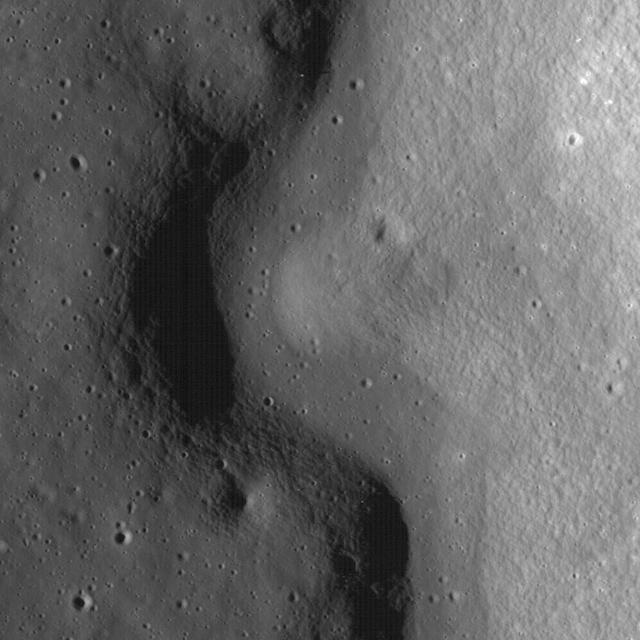A sinuous rille created by a lava flow snakes around the base of a massif in the Prinz-Harbinger region on the Moon in this image taken by NASA Lunar Reconnaissance Orbiter.