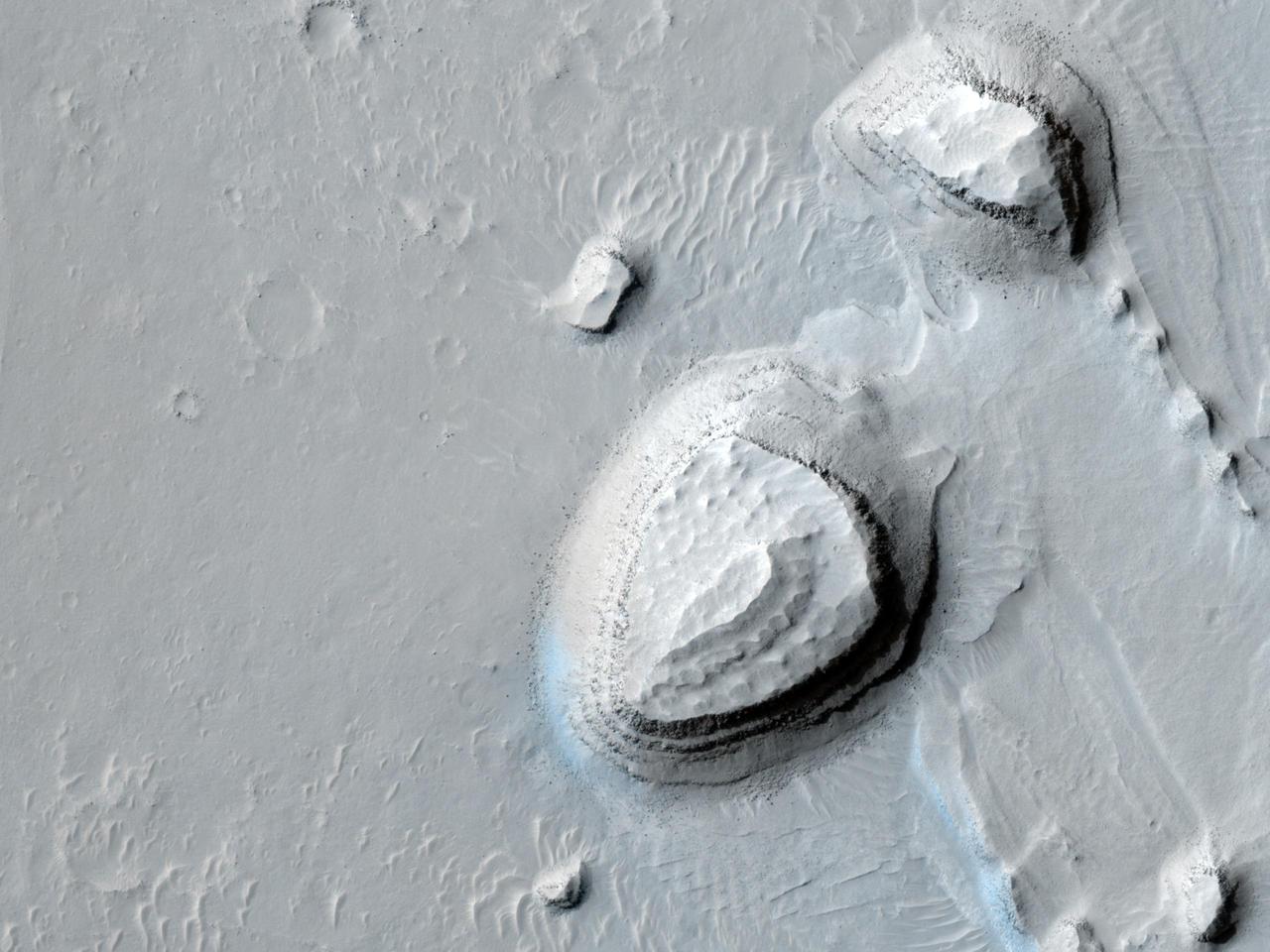 This image taken by NASA Mars Reconnaissance Orbiter shows a series of parallel layers eroding into peculiar knobs and hills.
