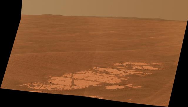 NASA Mars Exploration Rover Opportunity used its panoramic camera Pancam to capture this view approximately true-color view of the rim of Endeavour crater, the rover destination in a multi-year traverse along the sandy Martian landscape.