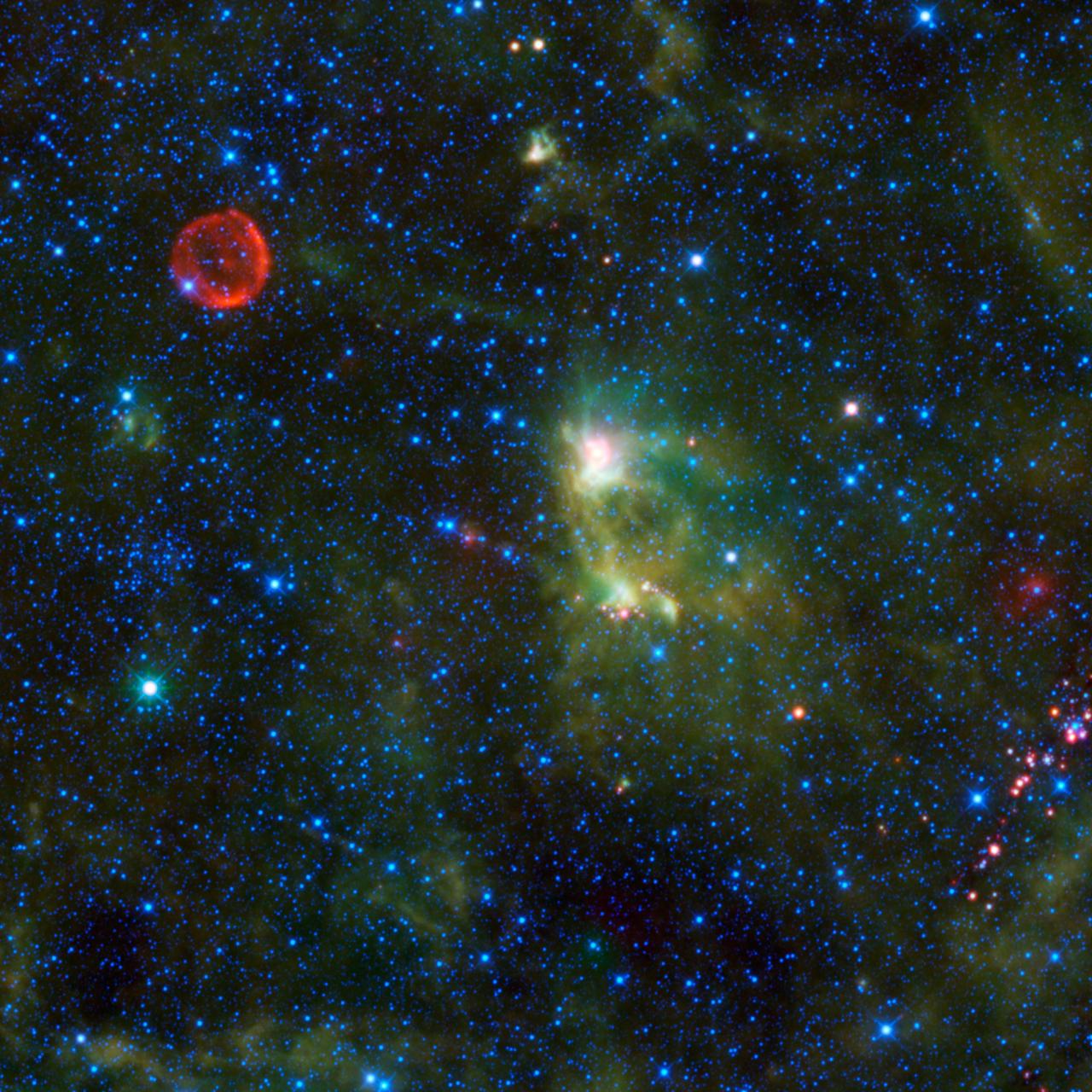 This image from NASA Wide-field Infrared Survey Explorer takes in several interesting objects in the constellation Cassiopeia which are not easily seen in visible light. The red circle visible at upper left is SN 1572, often called Tycho Supernova.