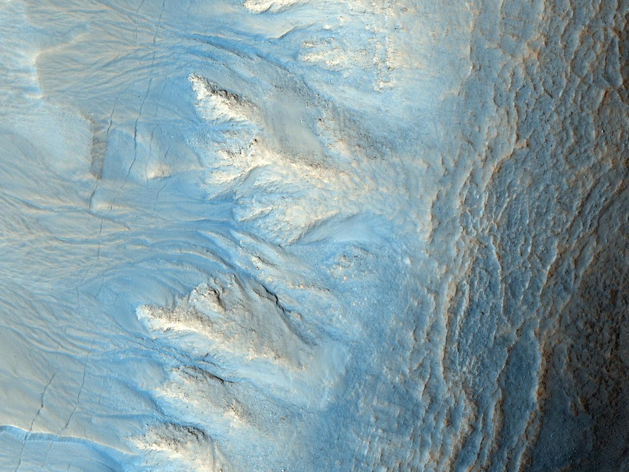 This image from NASA Mars Reconnaissance Orbiter shows the west-facing side of an impact crater in the mid-latitudes of Mars northern hemisphere. This crater has gullies along its walls that are composed of alcoves, channels and debris aprons.