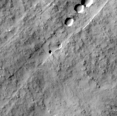 This image captured by NASA Mars Odyssey orbiter shows a Martian pit feature on the slope of an equatorial volcano named Pavonis Mons, appears to be a skylight in an underground lava tube.