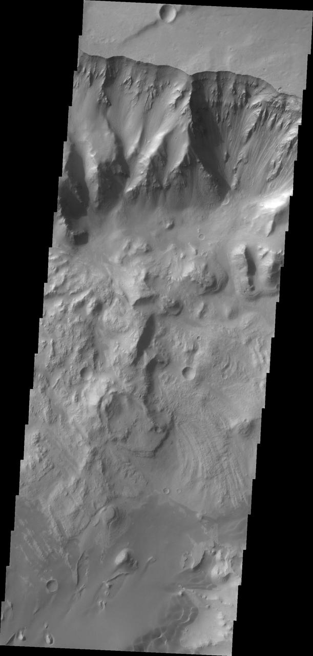This image captured by shows NASA 2001 Mars Odyssey the northern wall of Ganges Chasma. Dunes and a landslide deposit of visible at the bottom of the image.