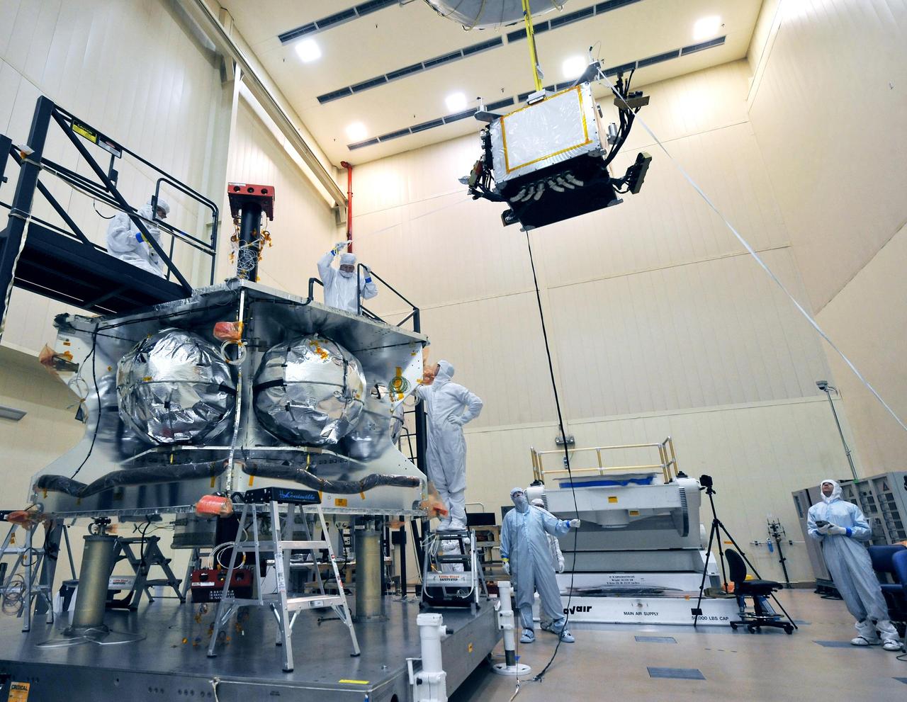 Technicians lowered a special radiation vault onto the propulsion module of NASA Juno spacecraft. The vault will dramatically slow the aging effect radiation has on the electronics for the duration of the mission.
