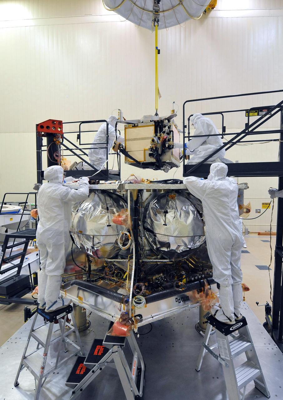 Workers place the special radiation vault for NASA Juno spacecraft onto the propulsion module. The whole vault, with more than 20 electronic assemblies inside, weighs about 200 kilograms 500 pounds.