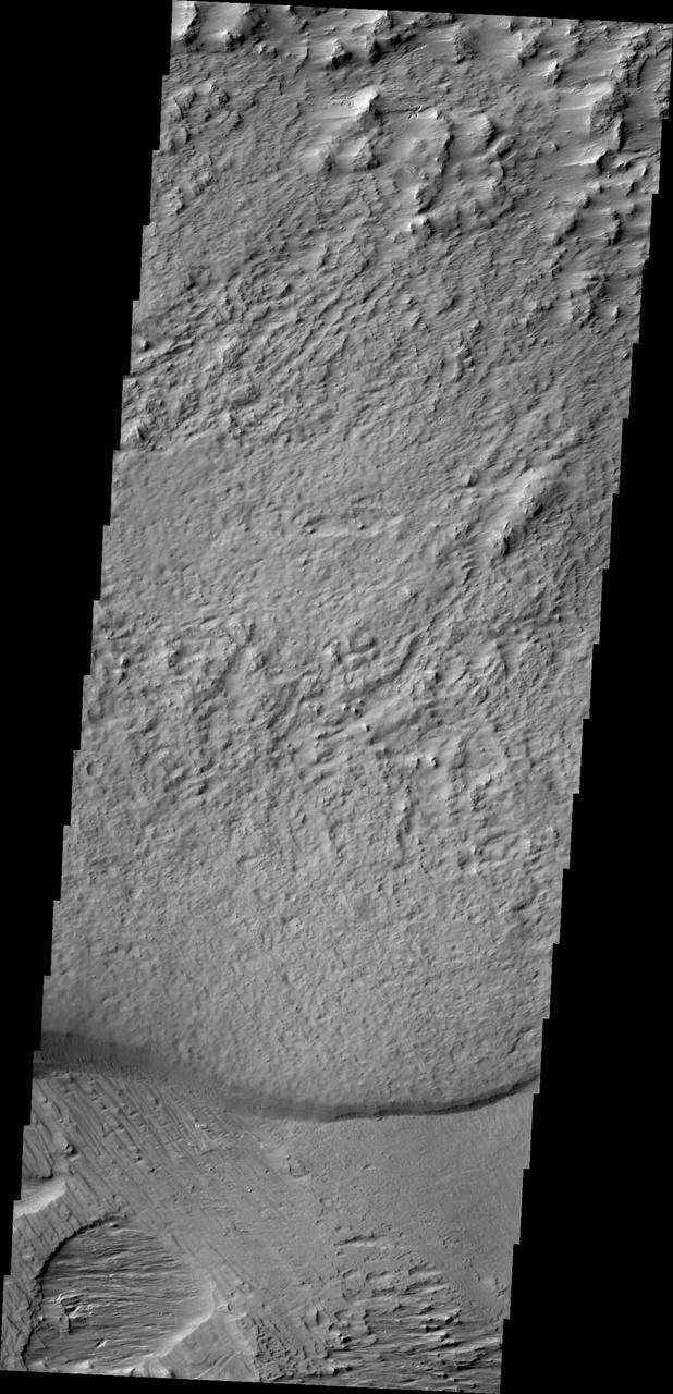 The region southwest of Olympus Mons is covered with materials that have been eroded by the wind. Surface materials in this area indicate wind action in many different directions as shown in this image from NASA Mars Odyssey.