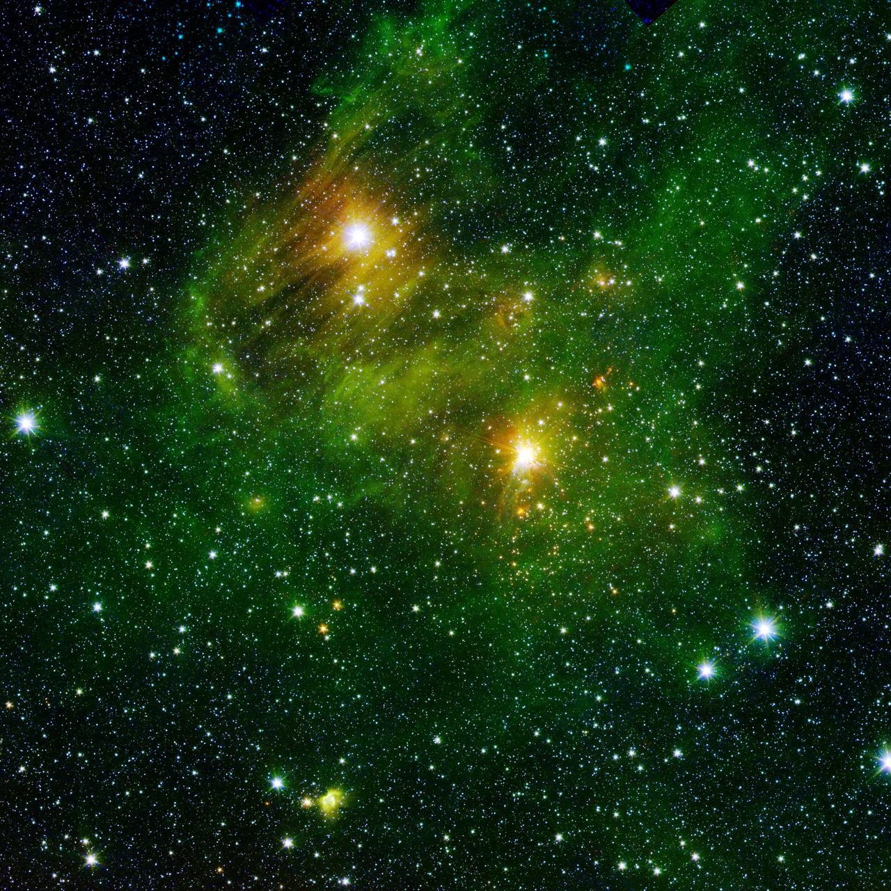 Two extremely bright stars illuminate a greenish mist in this image from the new GLIMPSE360 survey from NASA Spitzer Space Telescope. The fog is comprised of hydrogen and carbon compounds called polycyclic aromatic hydrocarbons.