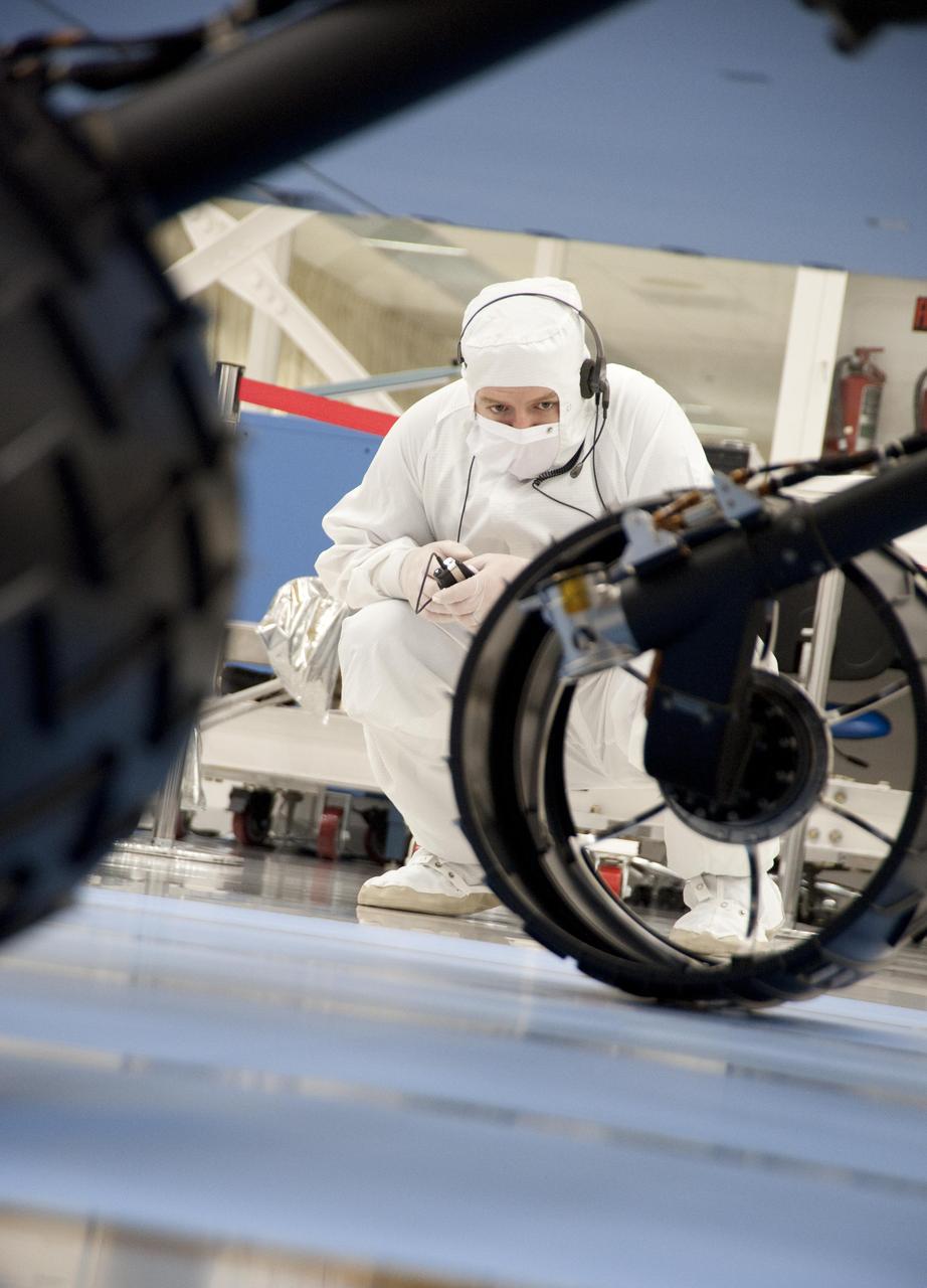 A test operator in clean-room garb observes rolling of the wheels during the first drive test of NASA Curiosity rover, on July 23, 2010. Technicians and engineers conducted the drive test at the Jet Propulsion Laboratory in Pasadena, Calif.