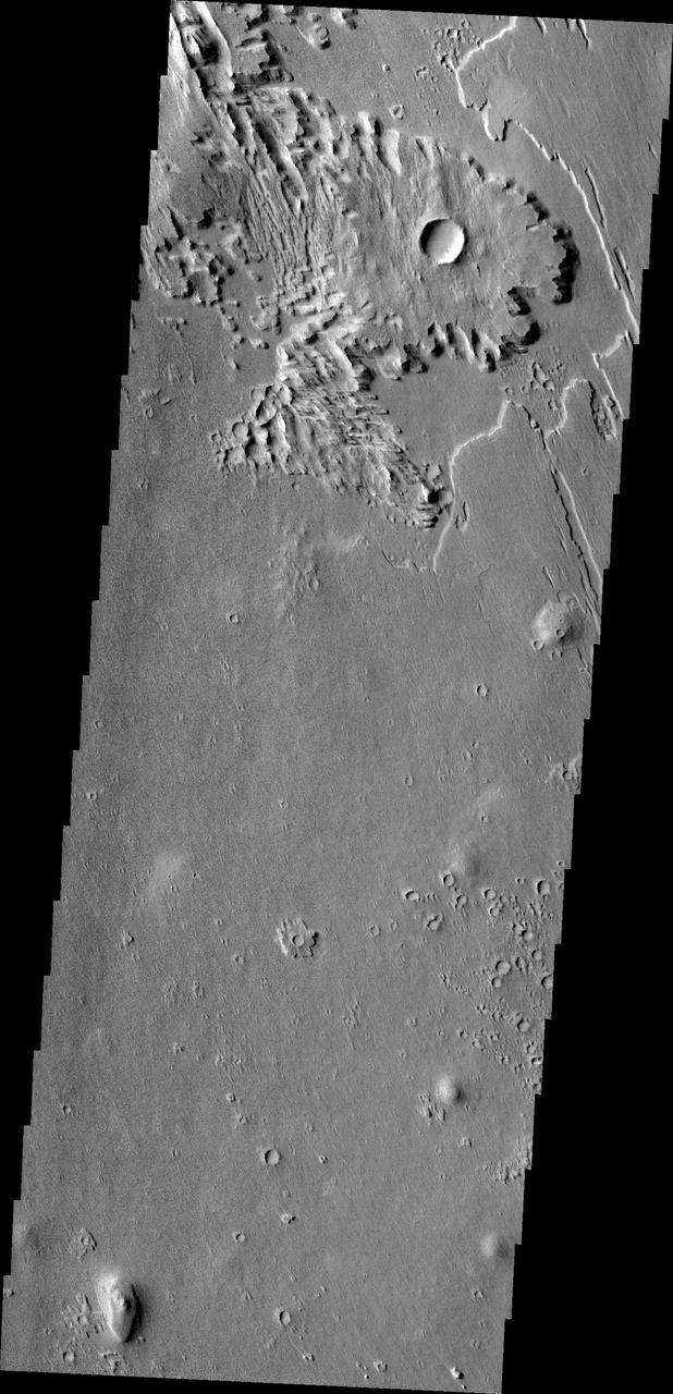 This wind eroded crater is located between Eumenides and Gordii Dorsa. The ejecta of the crater is more resistant to the wind than the surrounding materials in this image from NASA Mars Odyssey.