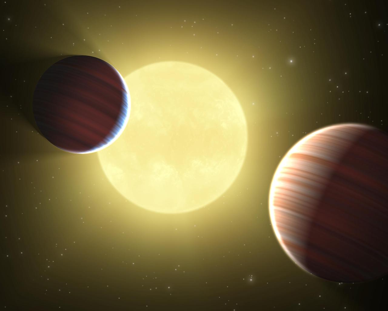 This artist concept illustrates the two Saturn-sized planets discovered by NASA Kepler mission. The star system is oriented edge-on, as seen by Kepler, such that both planets cross in front, or transit, their star, named Kepler-9.