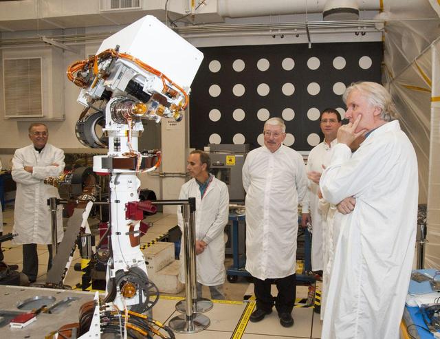 A group of members from the Jet Propulsion Laboratory watch the motions of an engineering model of the camera mast for NASA Mars rover Curiosity on March 5, 2010.