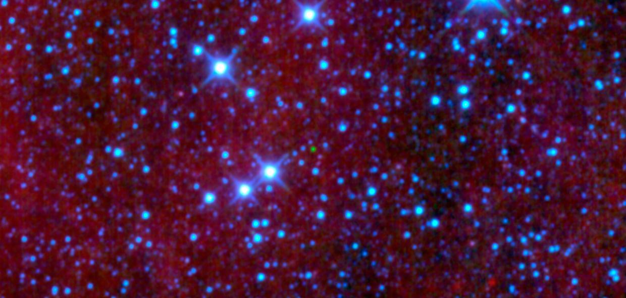 The green dot in the middle of this image might look like an emerald amidst glittering diamonds, but is a dim star belonging to a class called brown dwarfs; it is the first ultra-cool brown dwarf discovered by NASA Wide-field Infrared Survey Explorer.