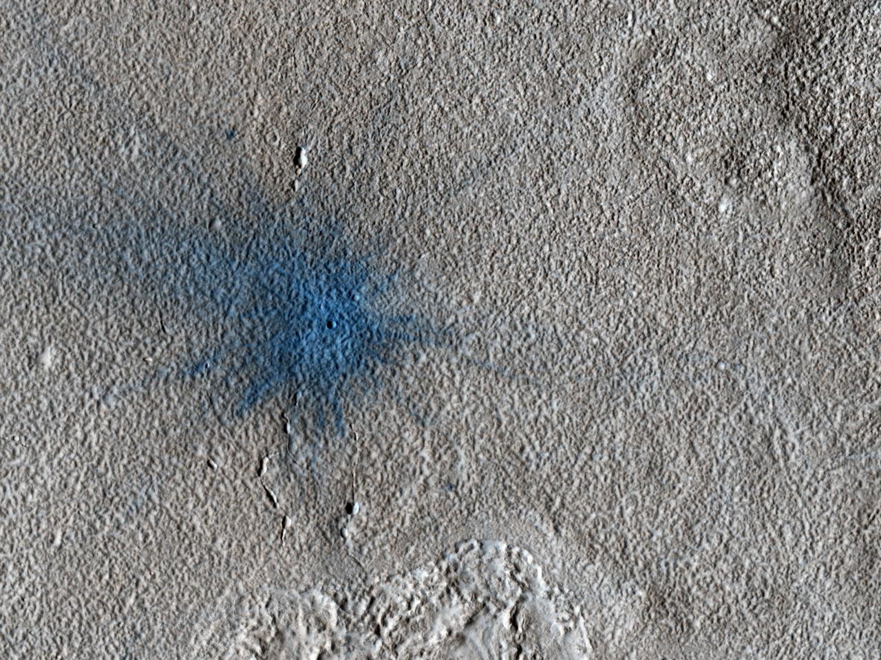This image from NASA Mars Reconnaissance Orbiter shows an approximately 7-meter diameter fresh crater and dark ejecta blanket. These small impact craters continue to form on Mars, and are most easily recognized in areas covered by bright dust.