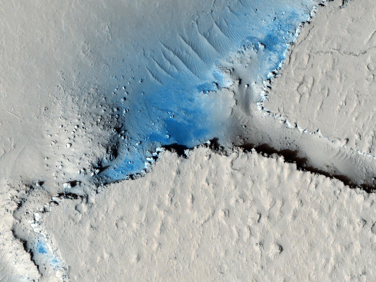 This observation from NASA Mars Reconnaissance Orbiter shows fractured mounds on the southern edge of Elysium Planitia. The fractures that crisscross their surfaces are probably composed of solidified lava.