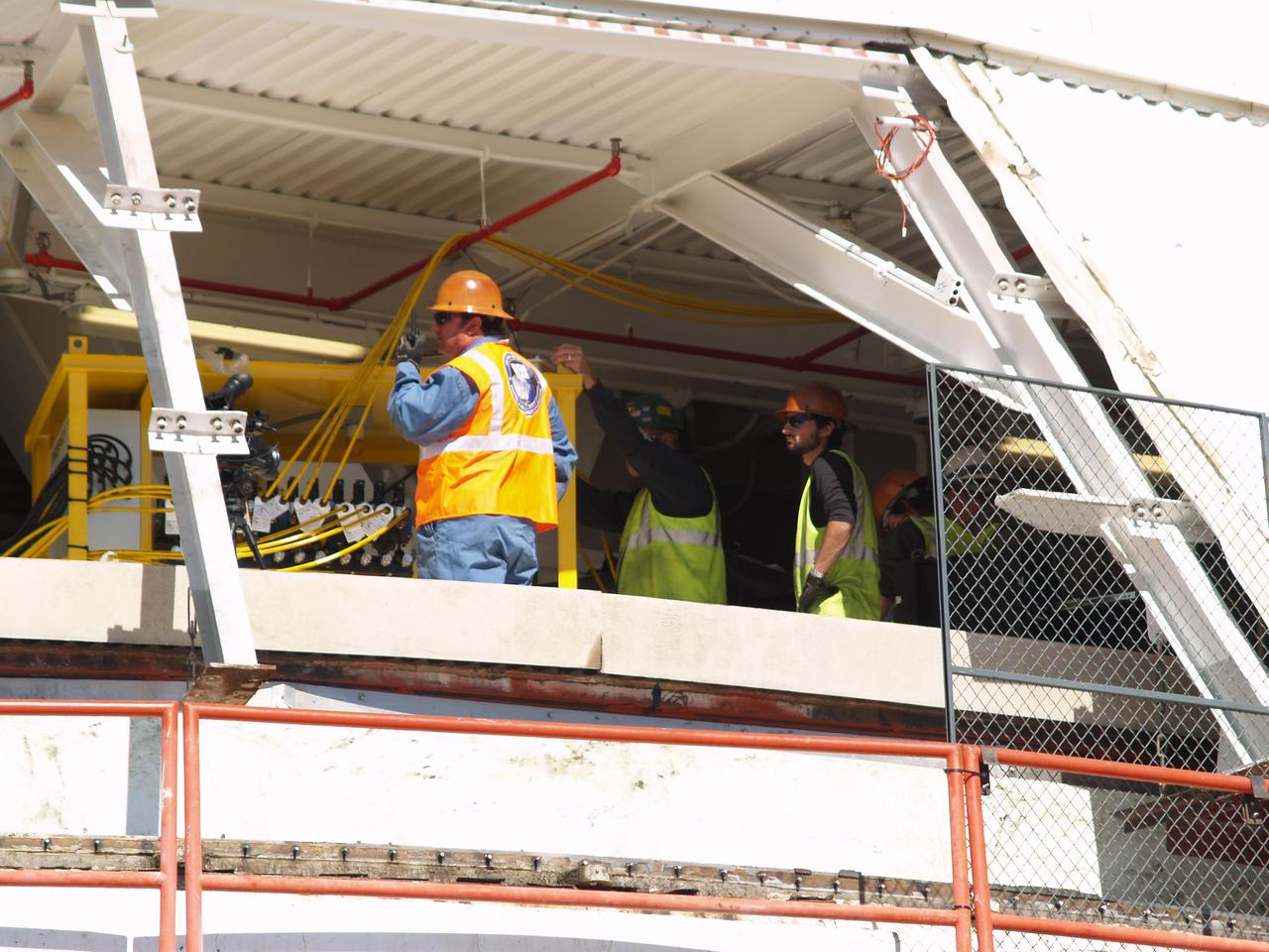 A worker at NASA Deep Space Network Goldstone Deep Space Communications Complex radios to his colleagues that 12 jacks are ready to lift the upper section of the giant Mars antenna.