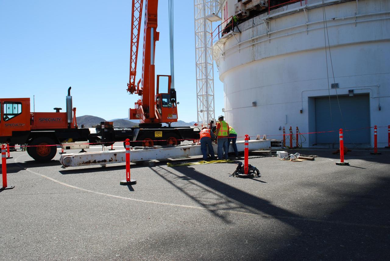 Workers at NASA Deep Space Network Goldstone Deep Space Communications Complex prepare a support leg that would help raise a portion of the giant Mars antenna.