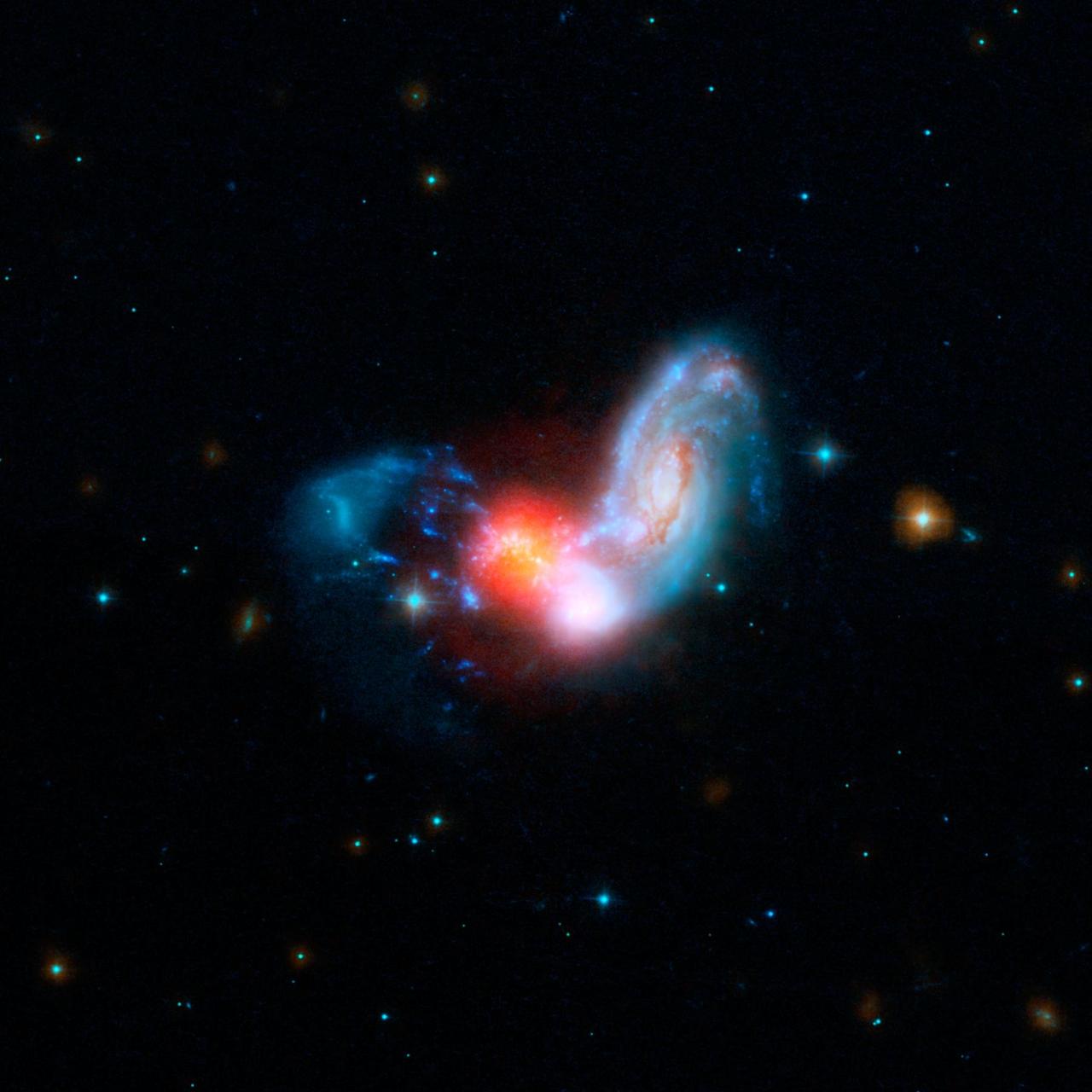 A brilliant burst of star formation is revealed in this image combining observations from NASA Spitzer and Hubble Space Telescopes. The collision of two spiral galaxies has triggered this luminous starburst.
