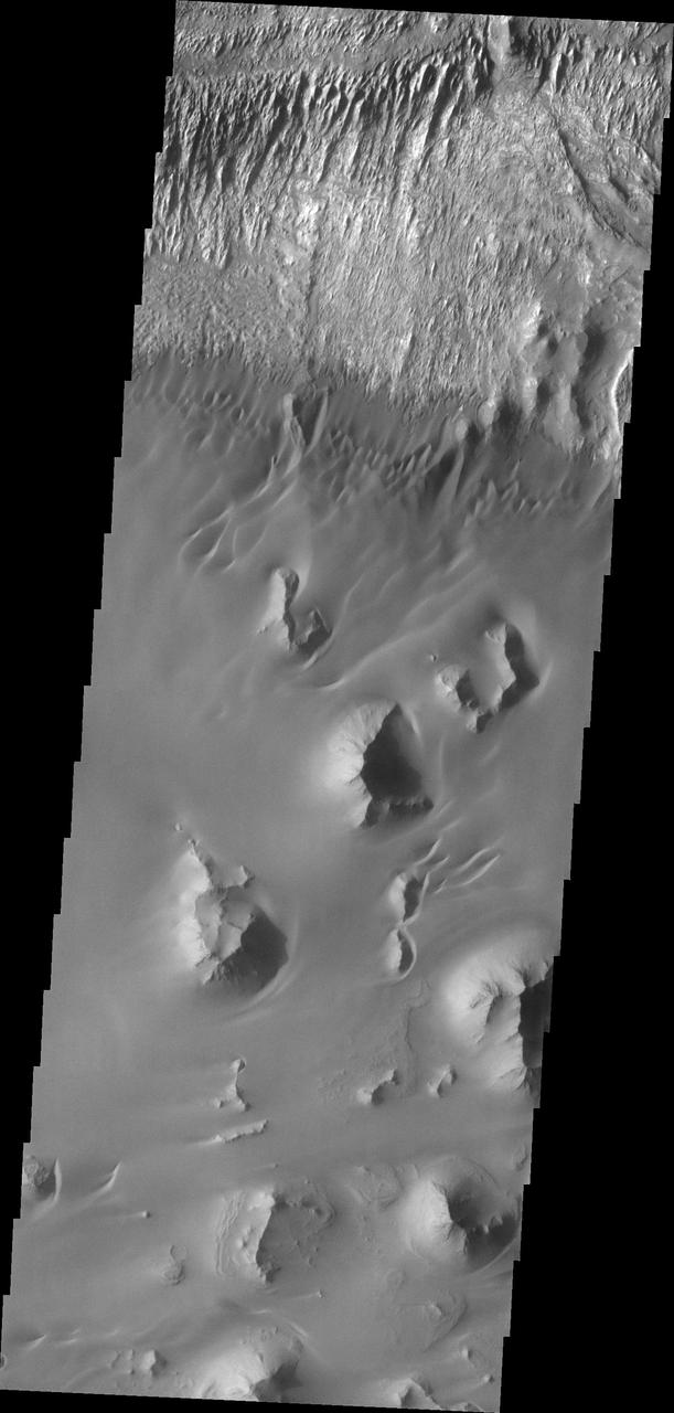 This image from NASA Mars Odyssey of the floor of Ganges Chasma shows eroded fill material and extensive sand deposits.