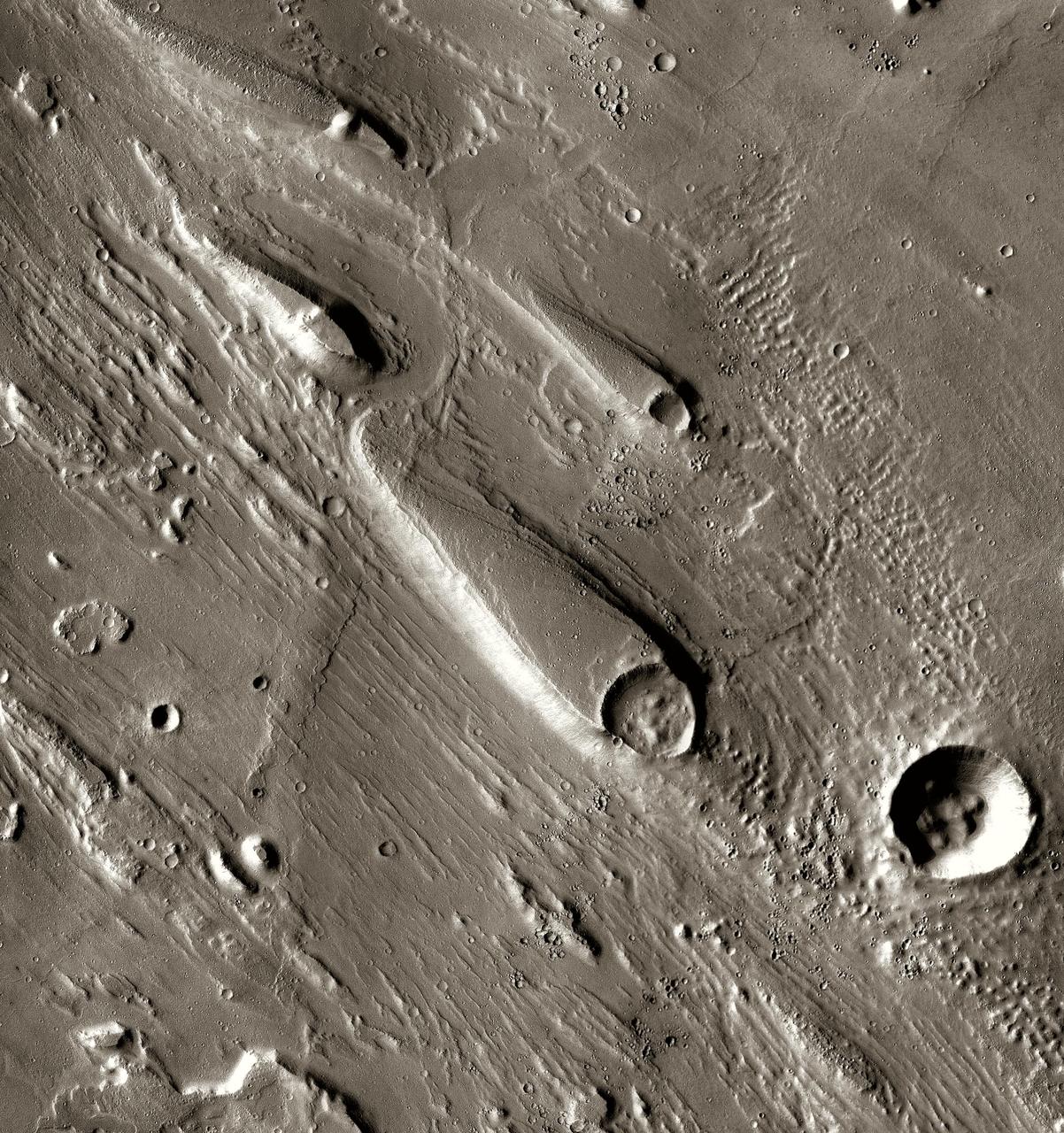 In Ares Vallis, teardrop mesas extend like pennants behind impact craters, where the raised rocky rims diverted the floods and protected the ground from erosion. This image is from NASA Mars Odyssey, one of an All Star set.