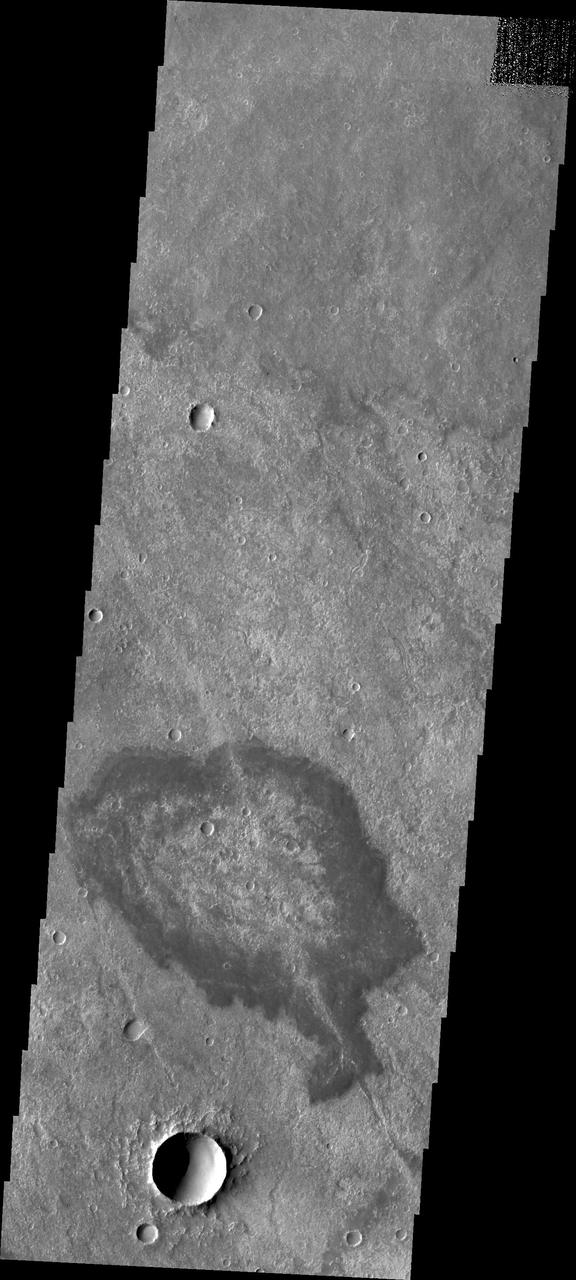 Located in Solis Planum, this unusual volcanic flow has margins darker than the surroundings. It appears that the flow originated in the linear fracture or vent that bisects the flow deposit. This image was captured by NASA Mars Odyssey.