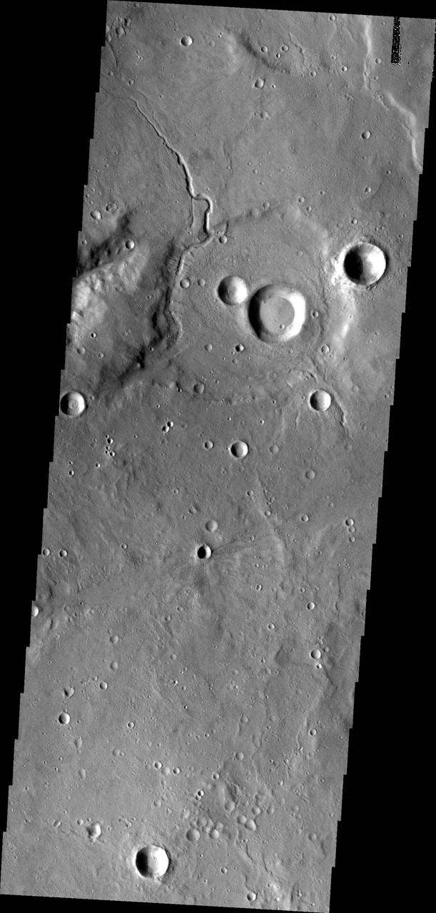 This image from NASA Mars Odyssey shows a small unnamed channel entering and running along the rim of this unnamed crater in Arabia Terra.