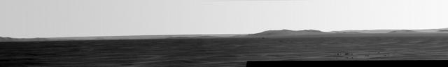 Rising highest above the horizon in the right half of the image, captured by NASA Mars Exporation Rover, is a portion of the western rim of Endeavour Crater including a ridge informally named Cape Tribulation.
