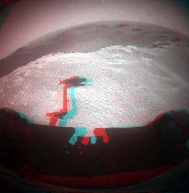 This image from NASA Mars Rover Opportunity is from the edge of a football-field-size crater informally named Santa Maria. The rover upraised robotic arm, itself out of view, casts a dragon-shaped shadow in the foreground. 3D glasses are necessary.
