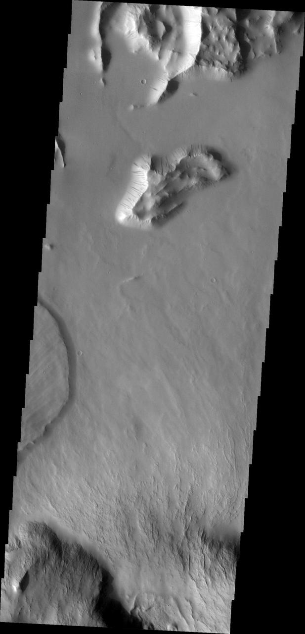 This image from NASA Mars Odyssey shows a small portion of the northern escarpment of Olympus Mons. The semi-circular deposit on the left side of the frame is a large landslide deposit.