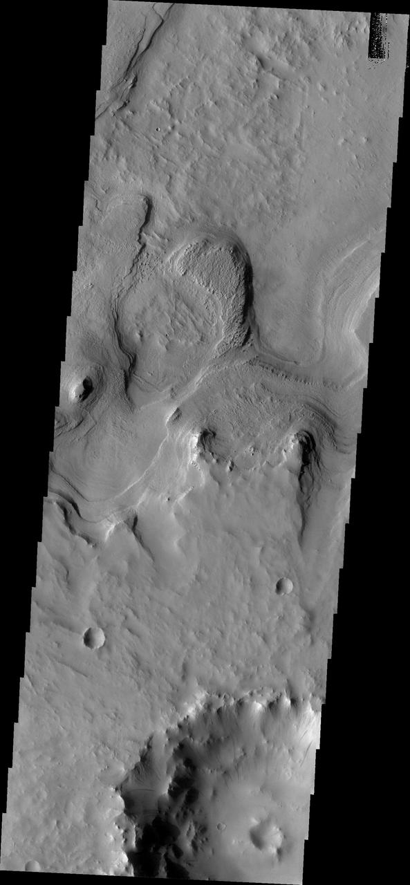This image from NASA Mars Odyssey shows layered material surrounding an unnamed crater in Terra Sabaea.