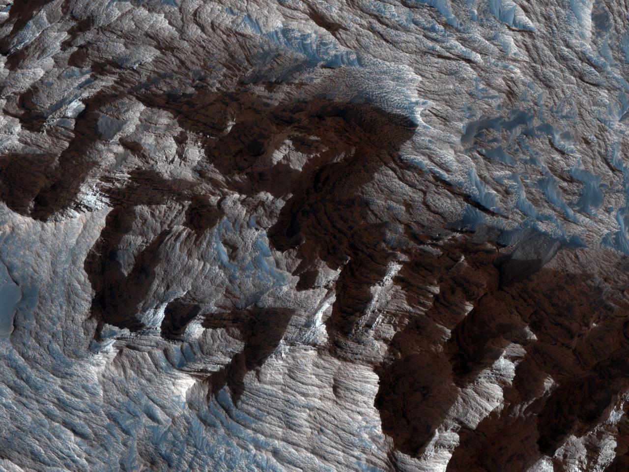 This image from NASA Mars Reconnaissance Orbiter shows an area of layered deposits in Candor Chasma. Sheets and dunes of dark-toned sand cover the light-toned, layered bedrock.