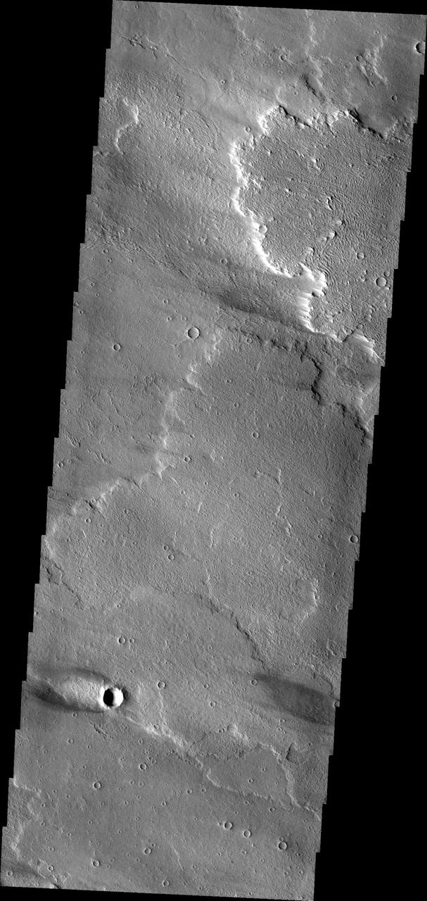 This windstreak is located on the volcanic plains of Daedalia Planum as seen by NASA Mars Odyssey. The dark outer margin is the region of dust being removed from the surface. The inner bright part is where dust is being deposited.