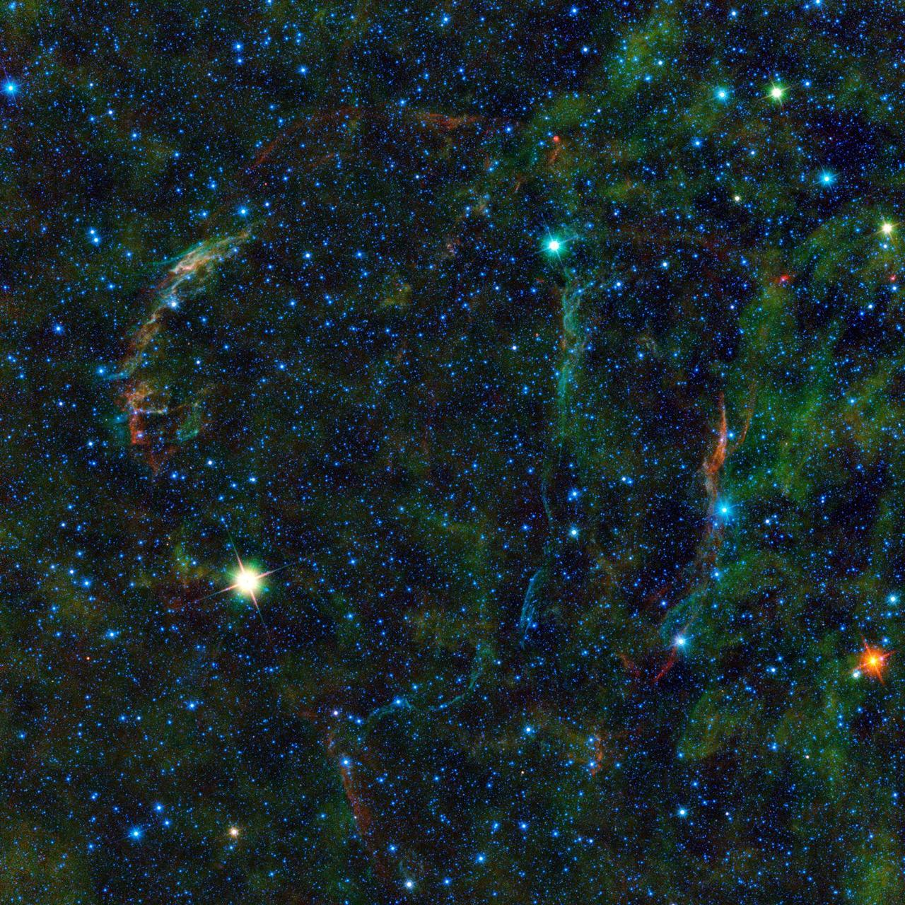 This large mosaic image from NASA Wide-field Infrared Survey Explorer, features the wreckage of an exploded star, as well as other stars nearing the end of their lives.
