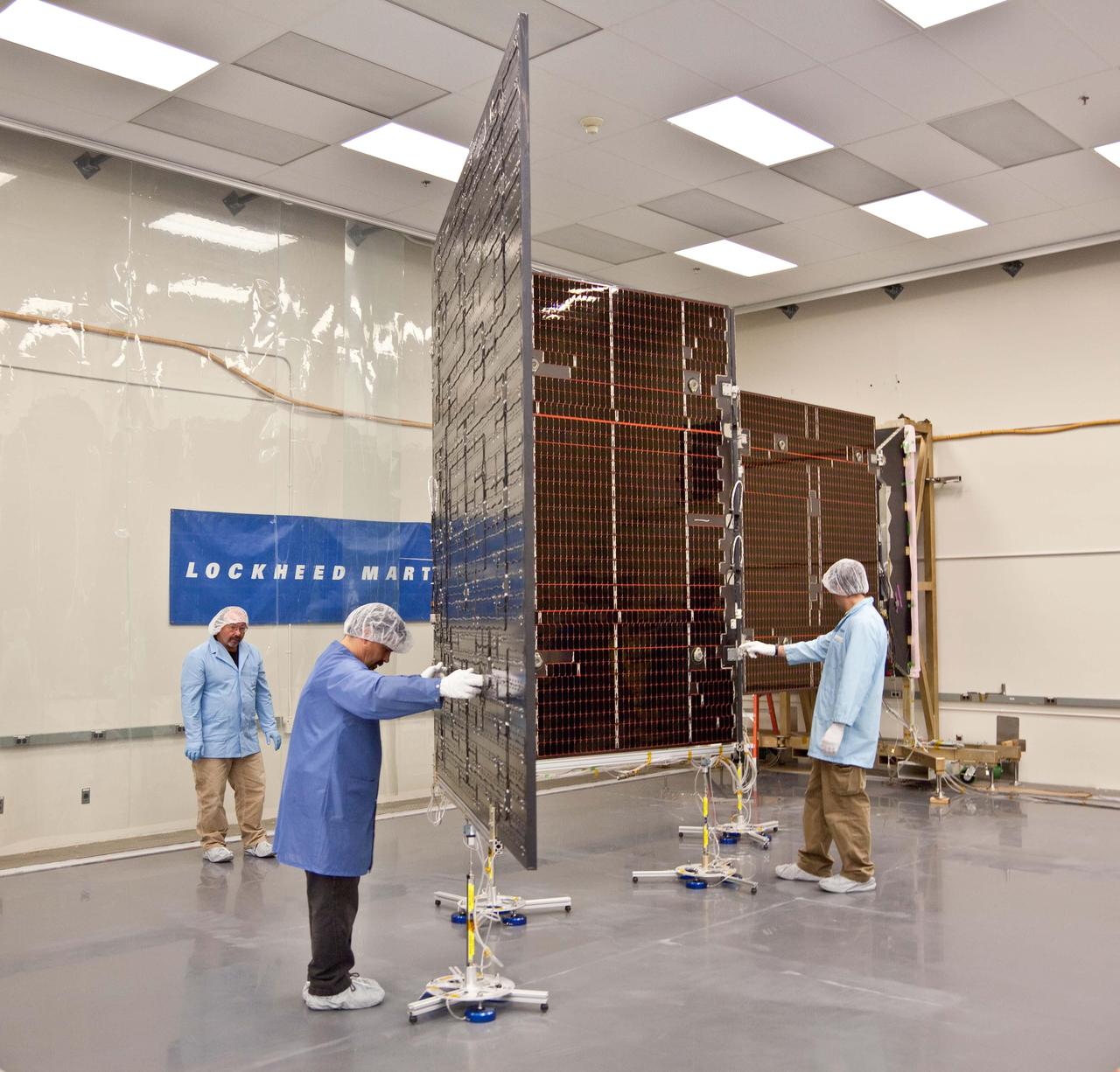 Technicians test the deployment of one of the three massive solar arrays that power NASA Juno spacecraft.